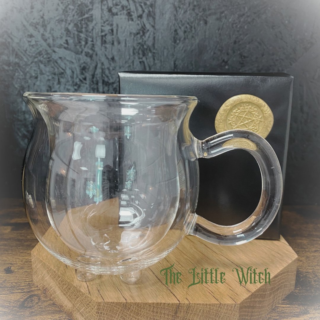 A double walled glass mug in the shape of a cauldron, complimentary black and gold The Little Witch brand gift wrapping