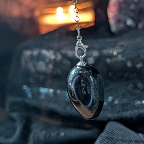 Black obsidian with flower of life detail with 'The Little Witch' branding on a blurred background