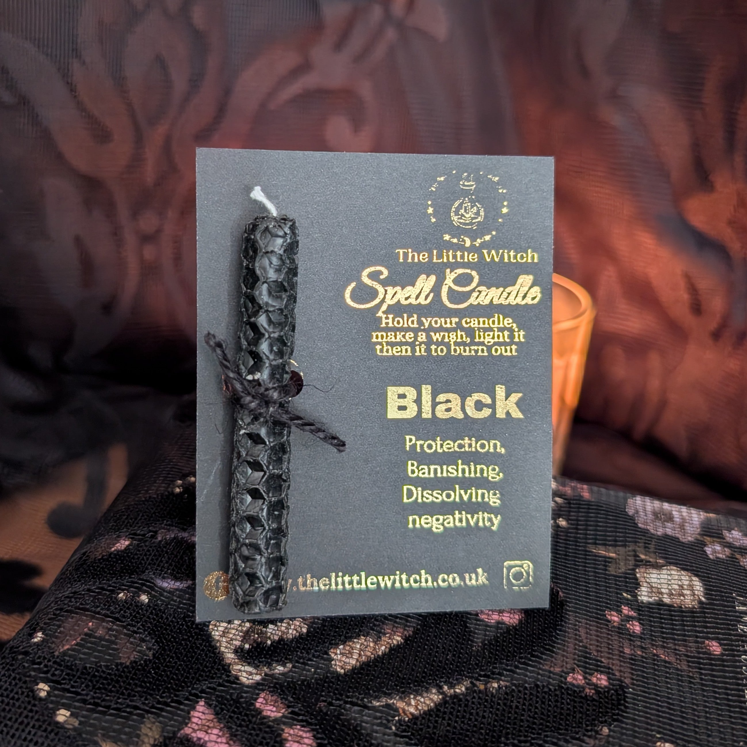 Black hand rolled beeswax candle mounted on a black and gold branded card