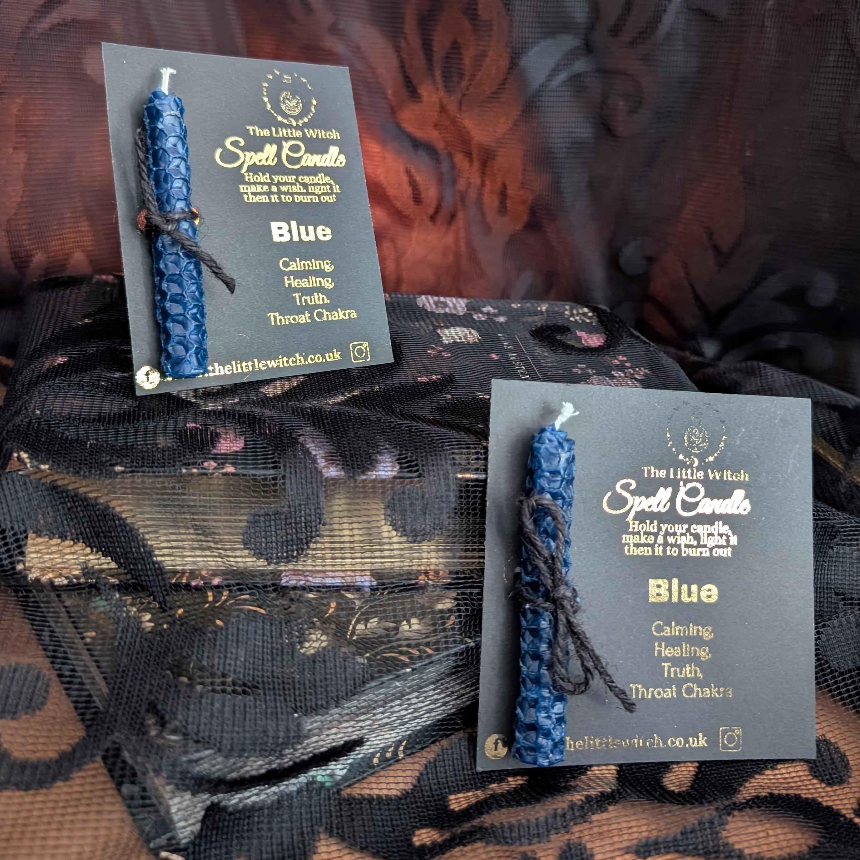 two blue beeswax candles mounted onto black card with 'The Little Witch' branding