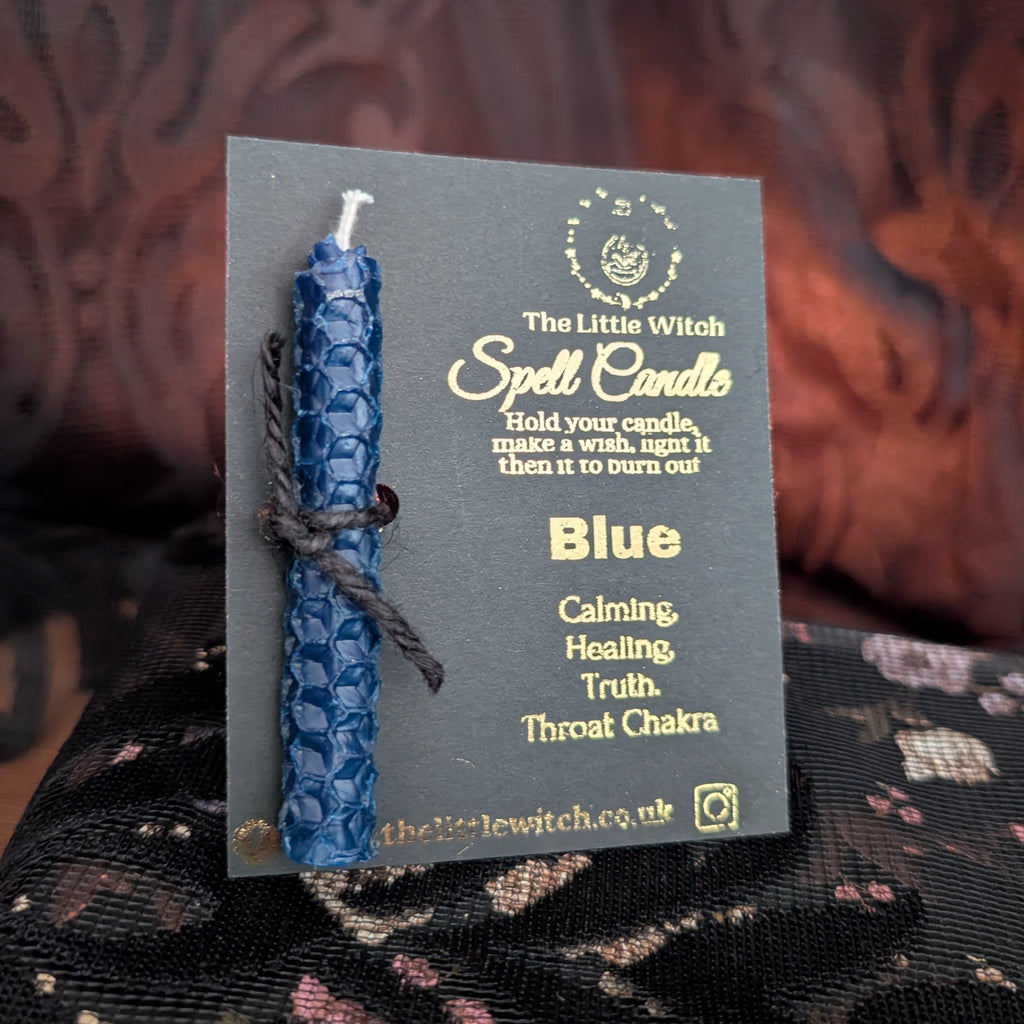 Blue beeswax candle mounted on black card with gold 'The Little witch' branding