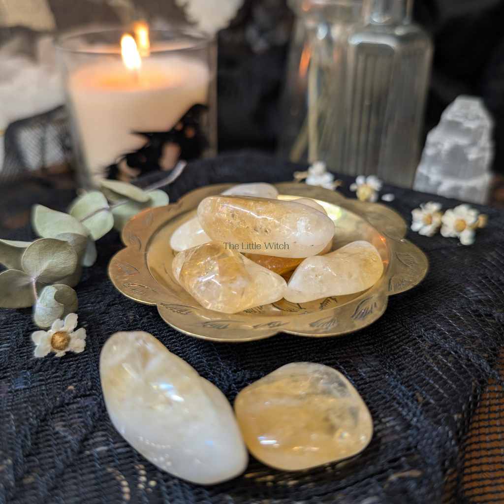 Crystal stones on a black cloth with a candle and decorative items in the background
