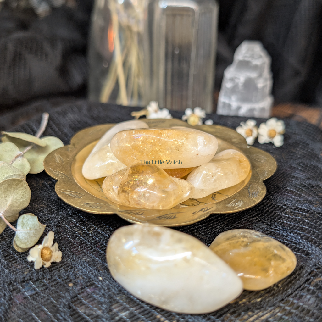 Crystal stones on a dark surface with 'The Little Witch' branding.