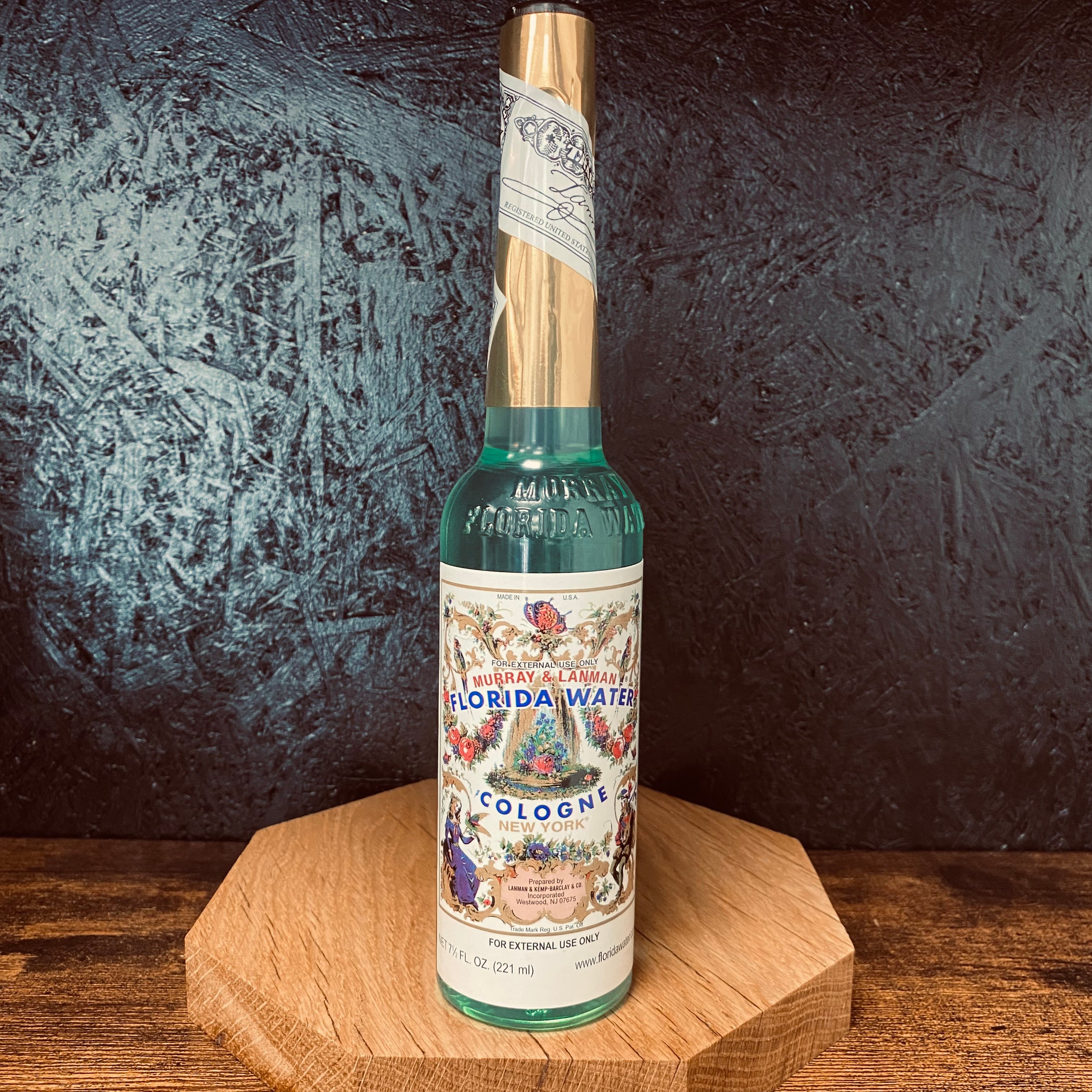 A bottle of Florida Water with a black textured background 