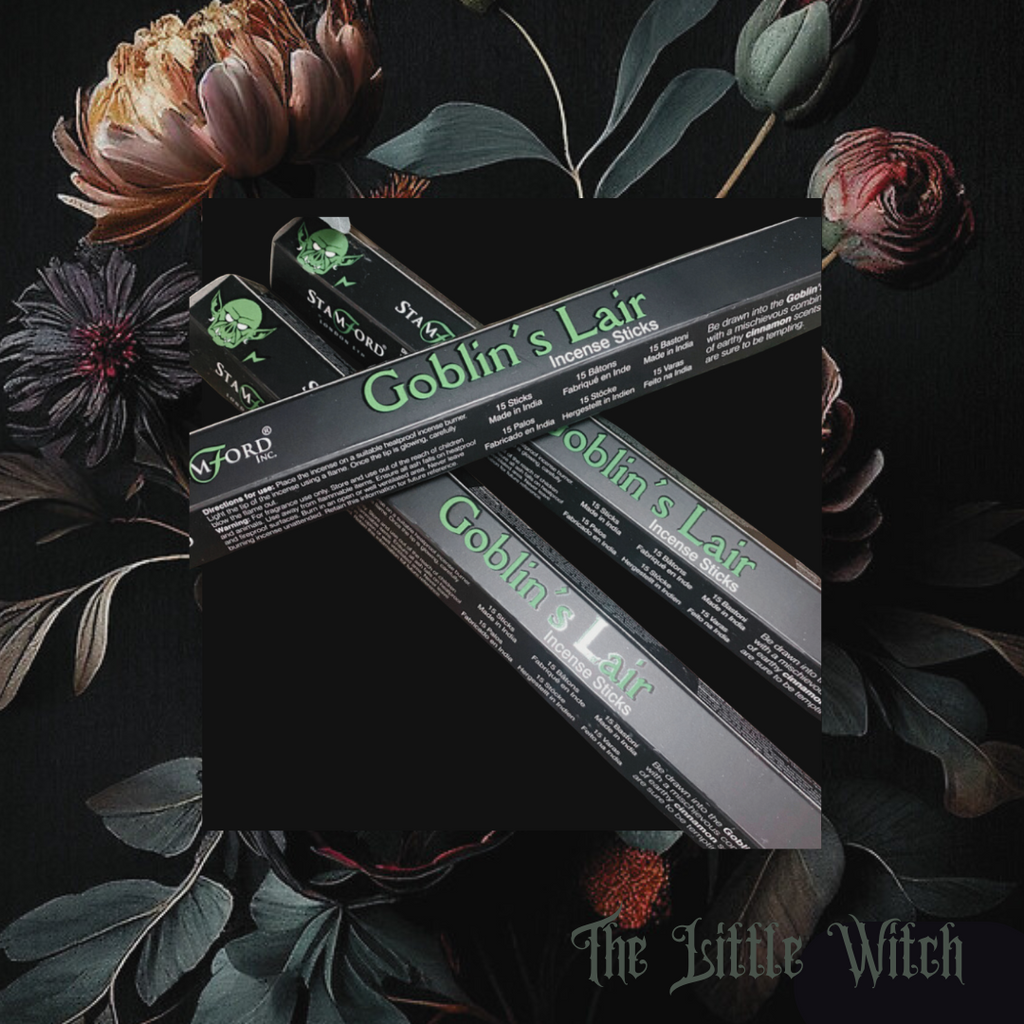 A set of incense sticks labeled 'Goblin's Lair' presented on a dark background with floral elements around them.