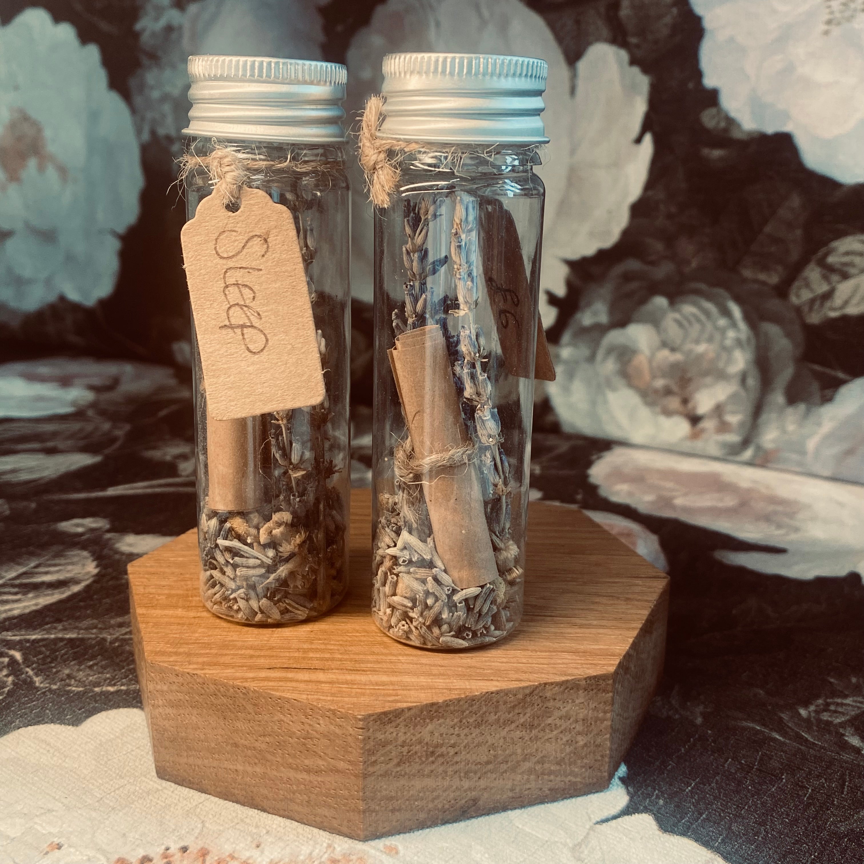 Plastic clear tube with silver screw top lid, a variety of preserved flowers and herbs to encourage restful sleep