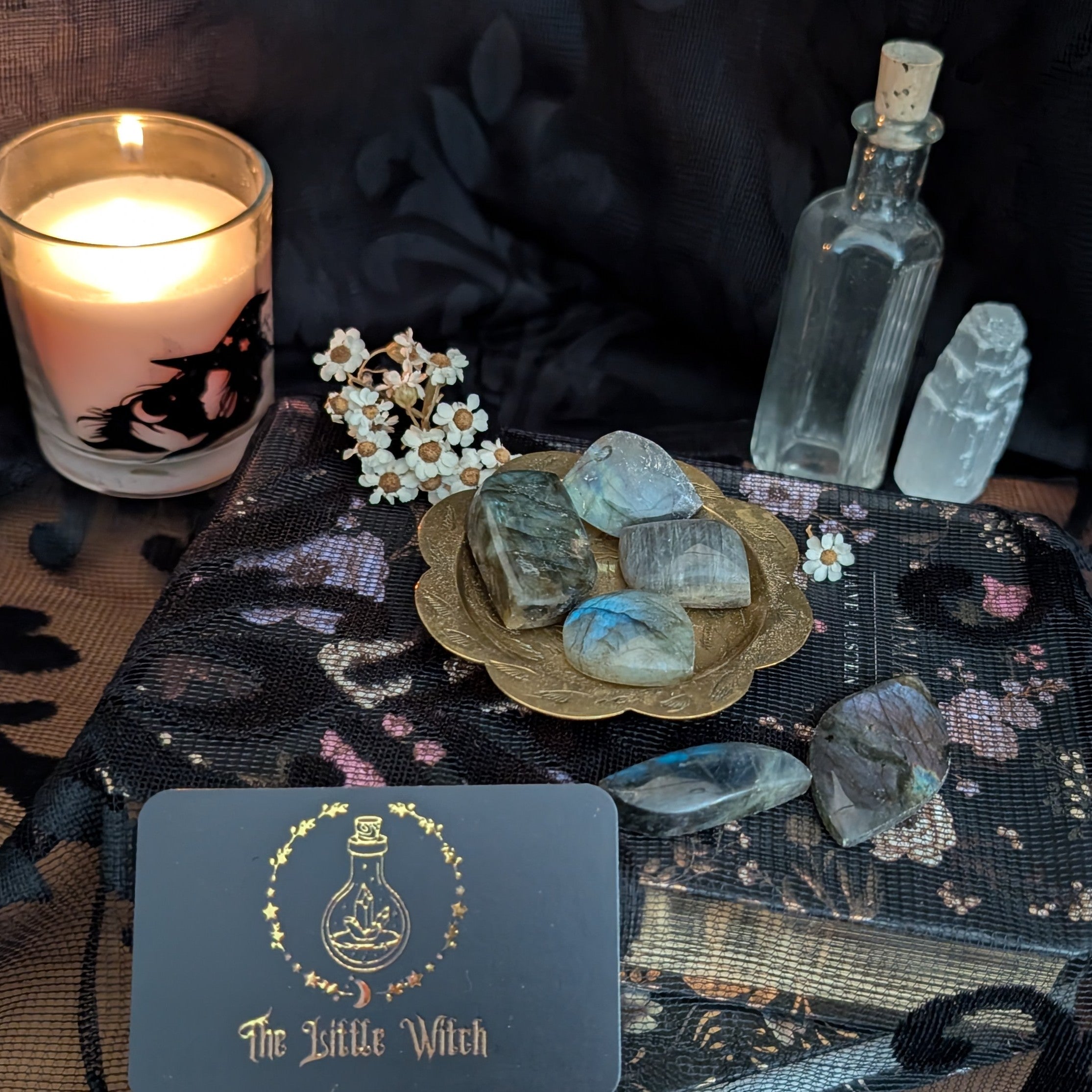Crystals in a gold dish with a black floral backdrop