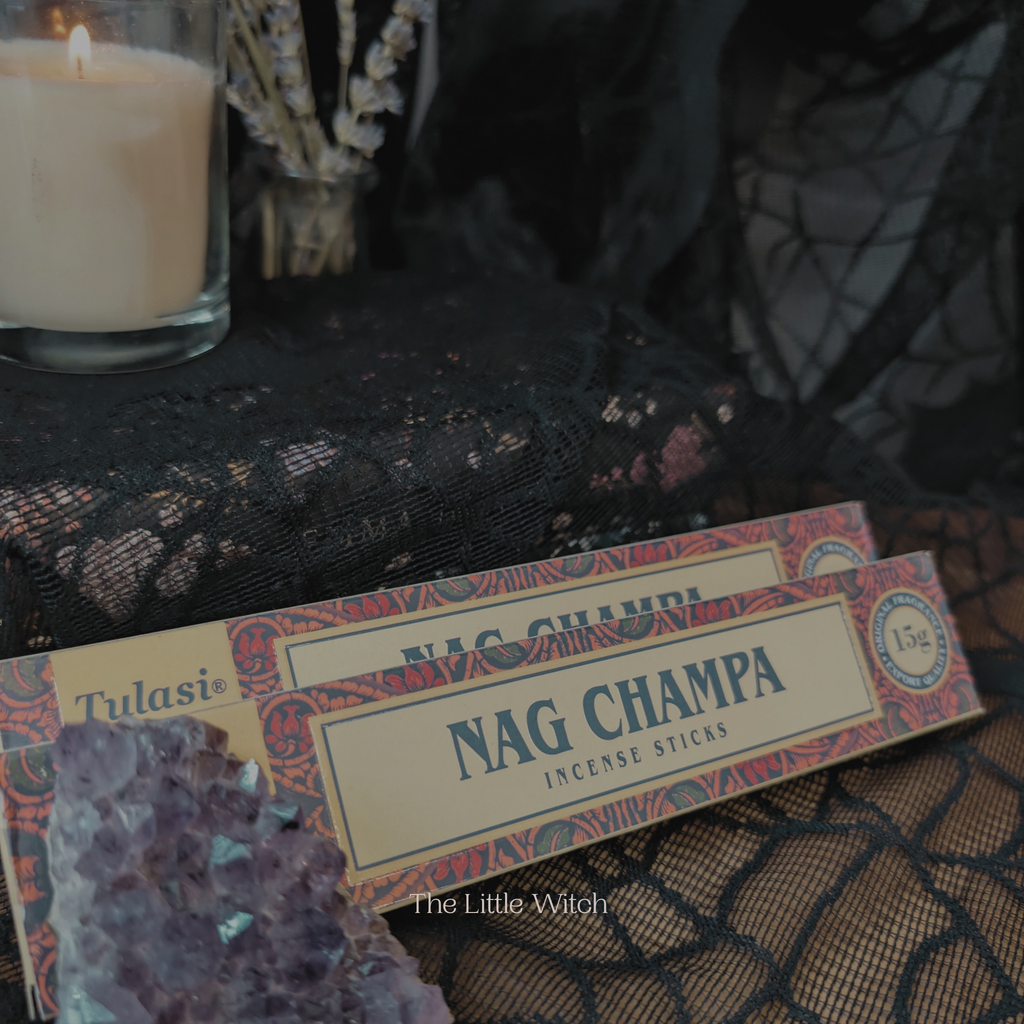 Nag Champa incense sticks with a candle and decorative elements on a textured surface