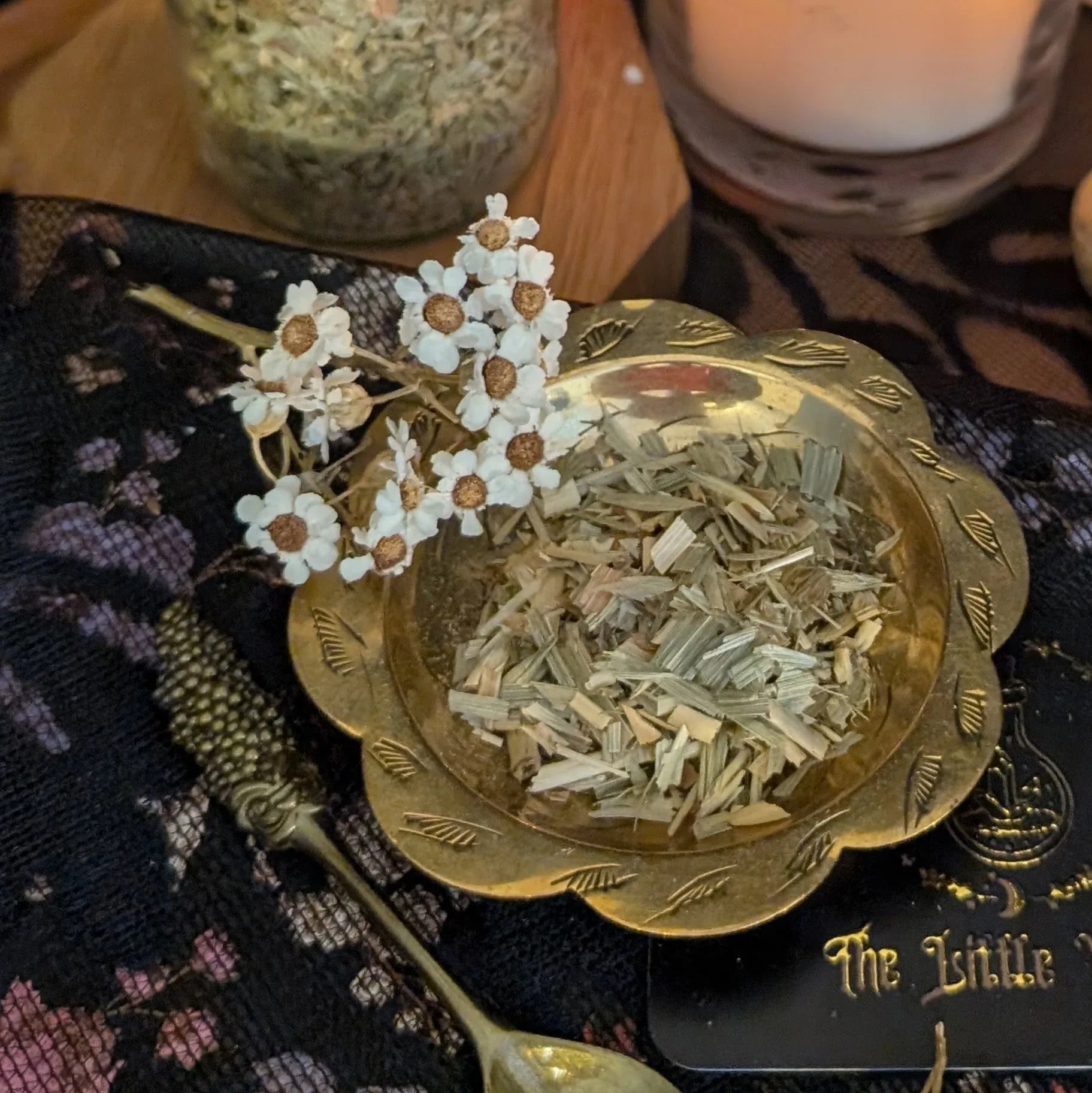 Oat Straw in a decorative gold bowl with dried flowers on a textured surface.