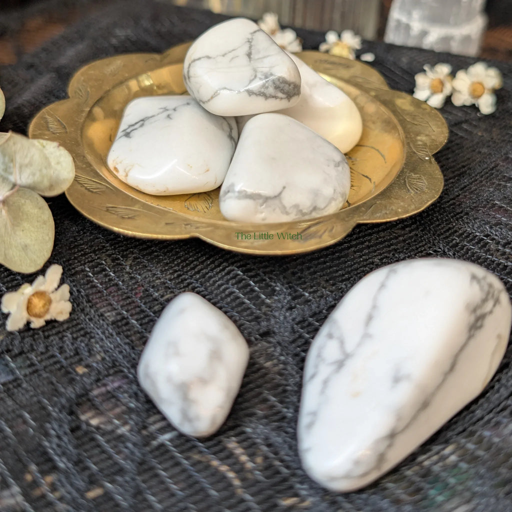 white Howlite crystals  on a decorative plate with flowers on a textured surface