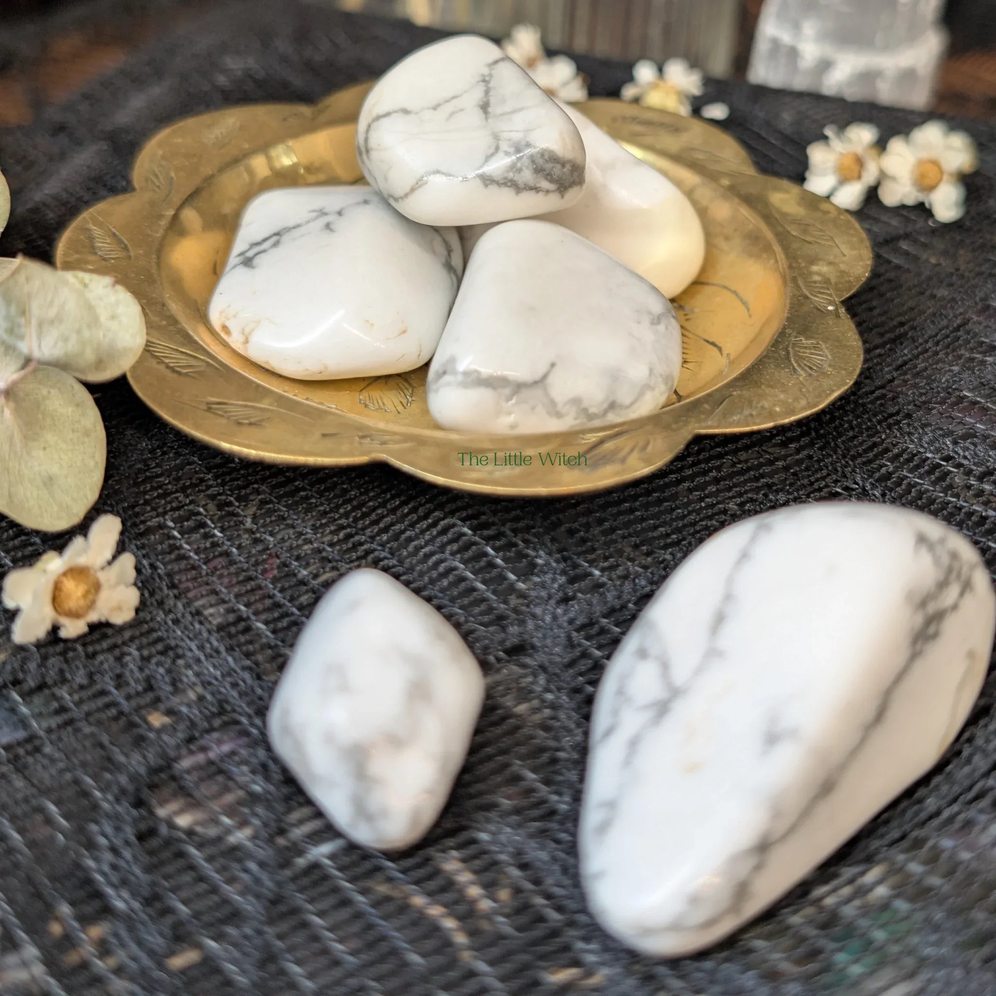 white Howlite crystals  on a decorative plate with flowers on a textured surface