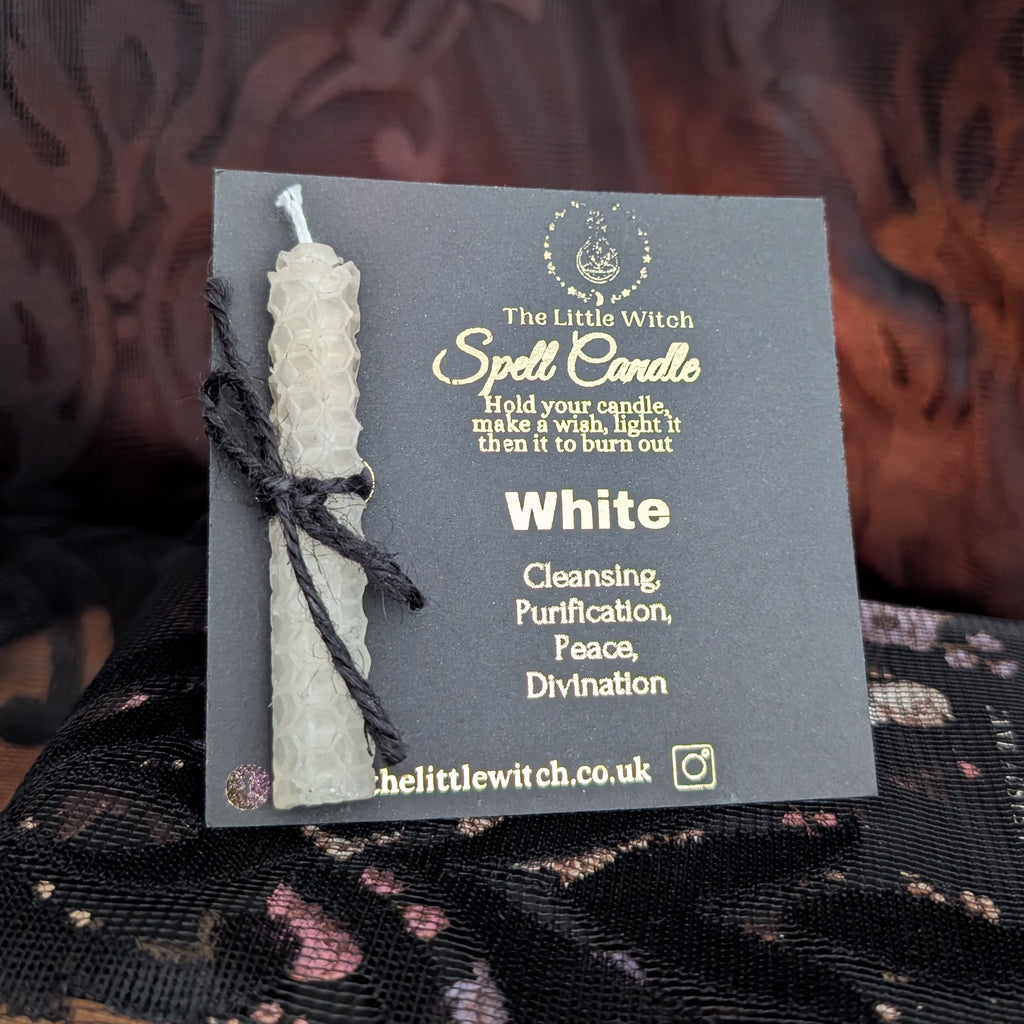 White beeswax spell candle mounted onto black card with gold 'The Little Witch' branding