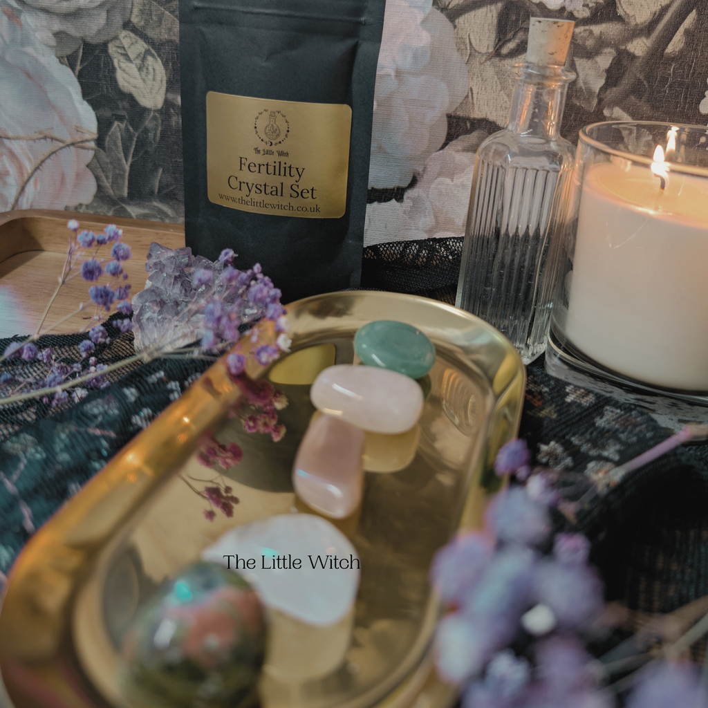 Witchcraft setup with crystals, candle, and herbs on a decorative tray.