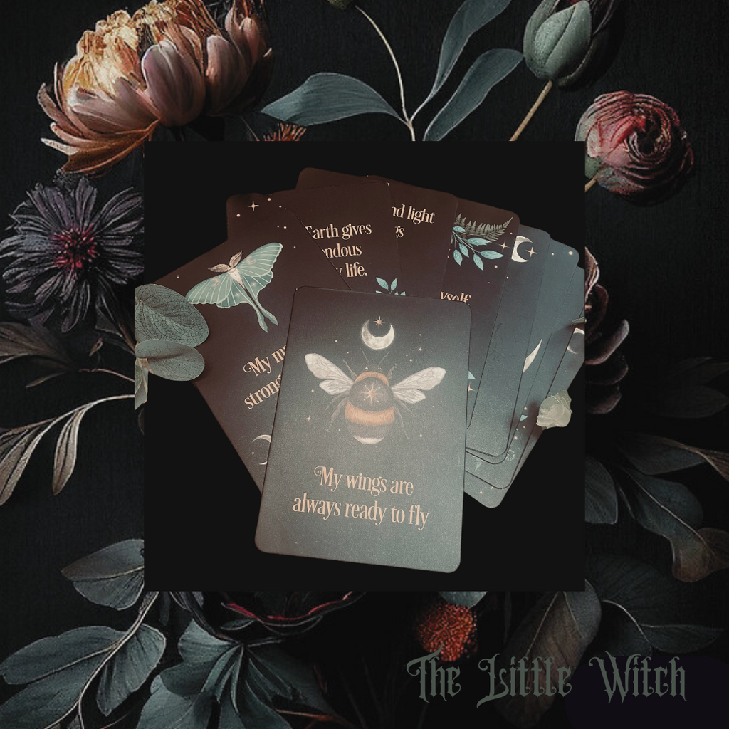 A spread of dark academia affirmation cards against a black backdrop with floral wallpaper