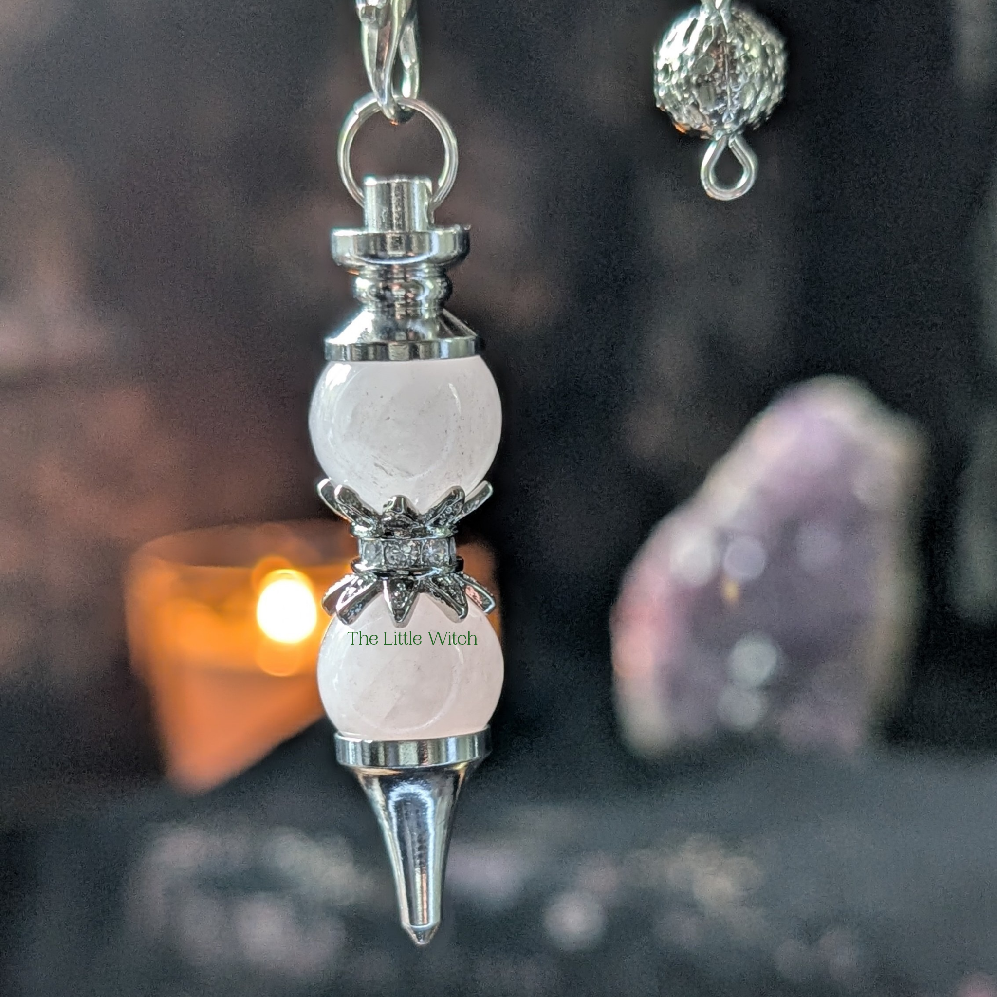 Double ball rose quartz pendulum with candle light and amethyst geode