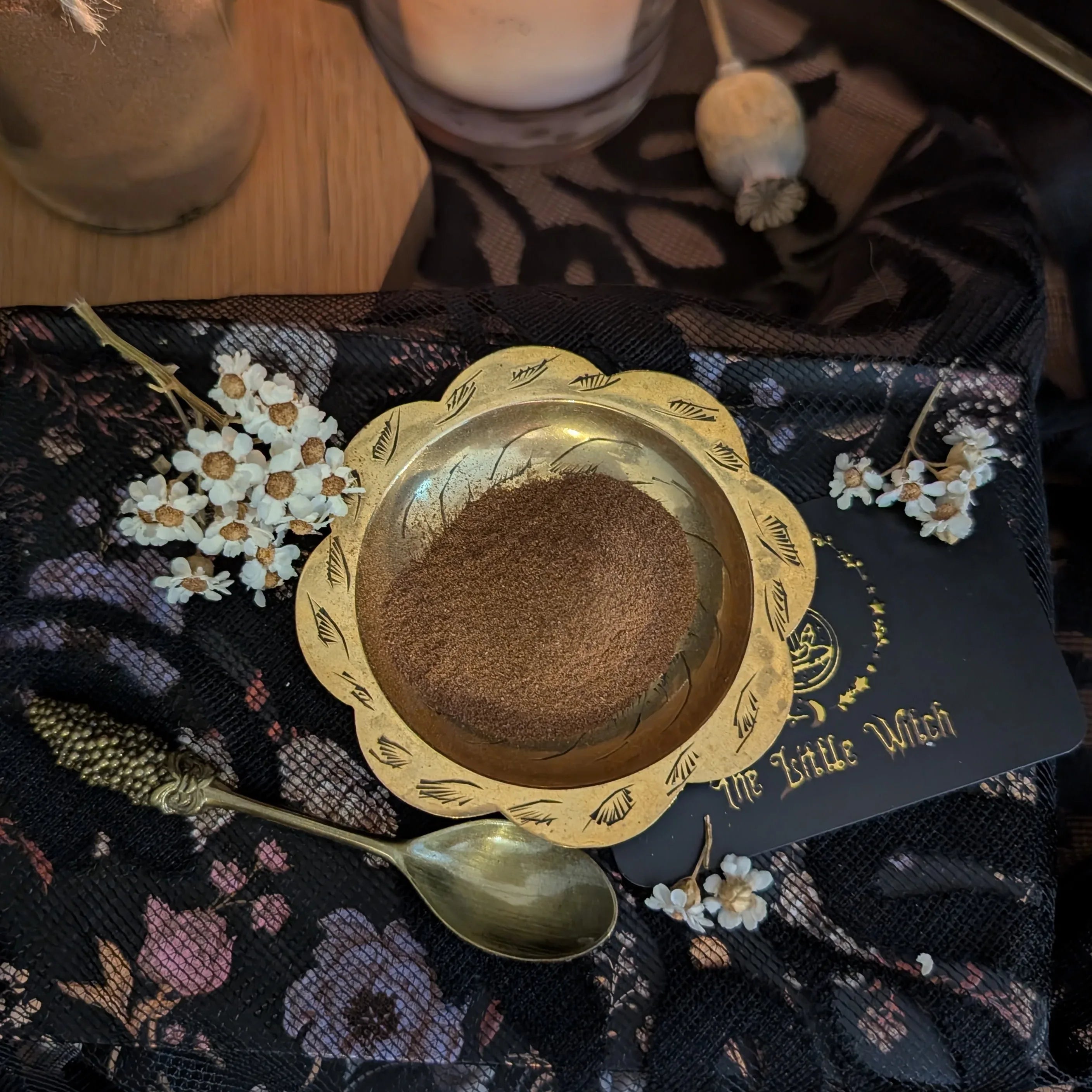 Gold bowl with cinnamon on a decorative black surface with floral elements