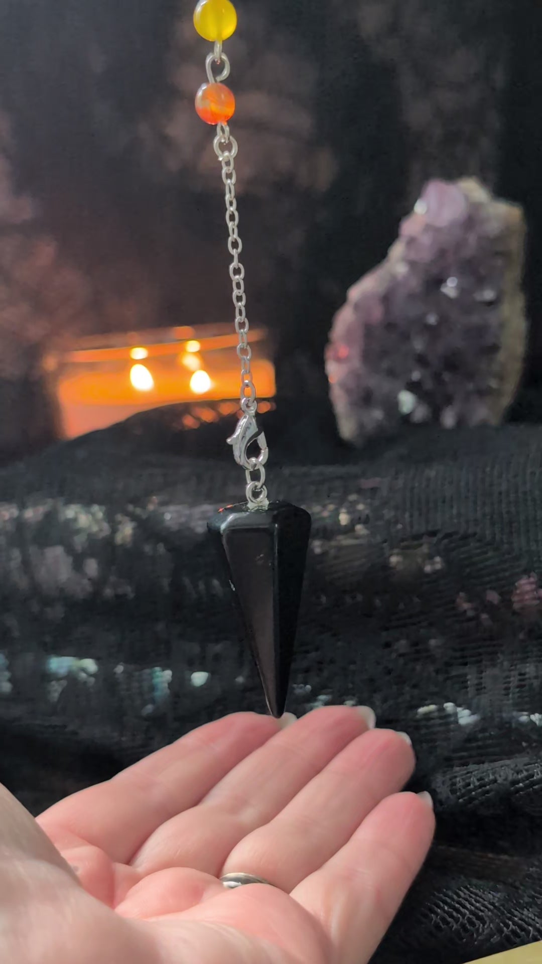 A black obsidian pendulum with a crystal bead for each chakra answering yes or no questions 