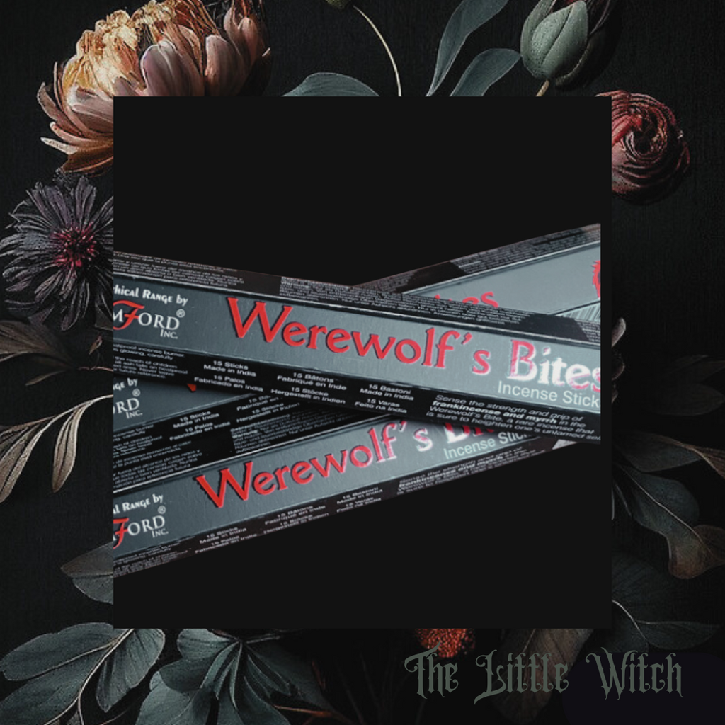A box of Werewolf's Bite incense sticks with a black and red color scheme, placed on a surface with floral designs.