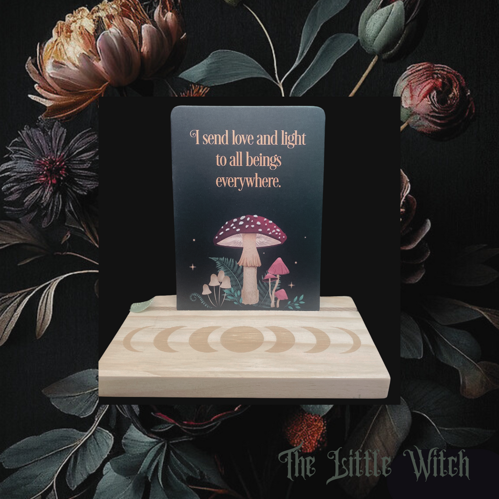 wooden stand engraved with the moon phases, affirmation card reads 'I send love and light to all beings everywhere'
